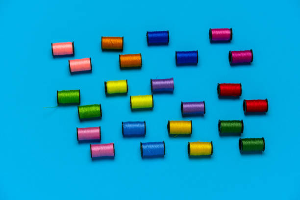top view creative still life flat lay with reels of multicolored threads pattern on a blue background