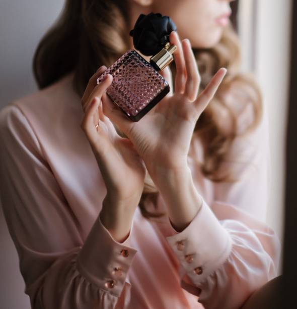 bride in wedding dress enjoys a perfume close-up