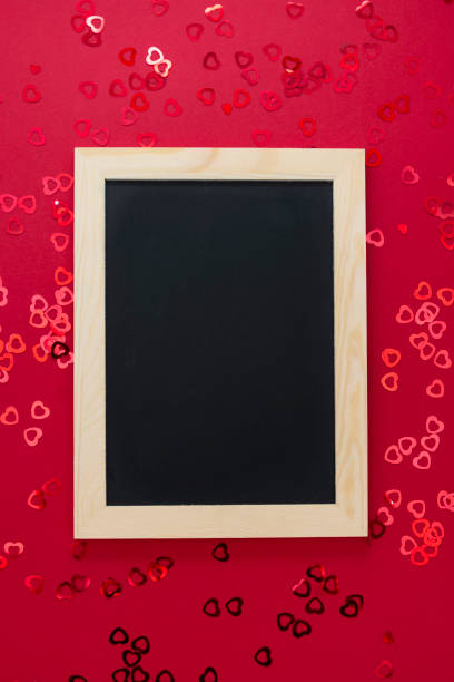 top view of empty blackboard on red background with shiny confett. - epmty imagens e fotografias de stock