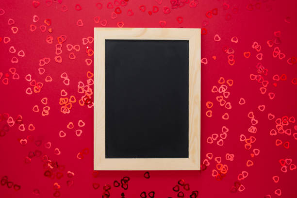 top view of empty blackboard on red background with shiny confett. - epmty imagens e fotografias de stock