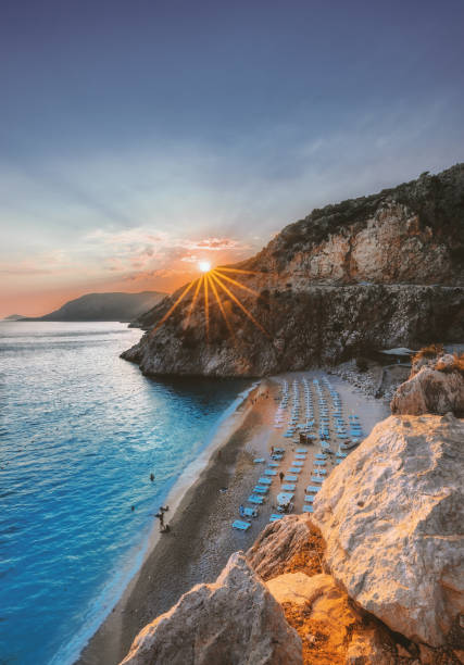 tramonto sulla spiaggia di kaputas a kalkan, antalya - mountain looking at view beach cliff foto e immagini stock