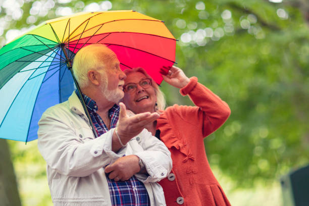gouttes de pluie - umbrella senior adult couple autumn photos et images de collection