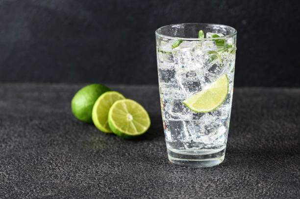 Glass of sparkling water Glass of sparkling water with ice cubes and slice of lime carbonated water photos stock pictures, royalty-free photos & images