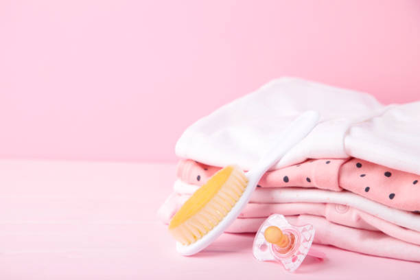 istock Baby clothes with comb on pink background with copy space 1199520301