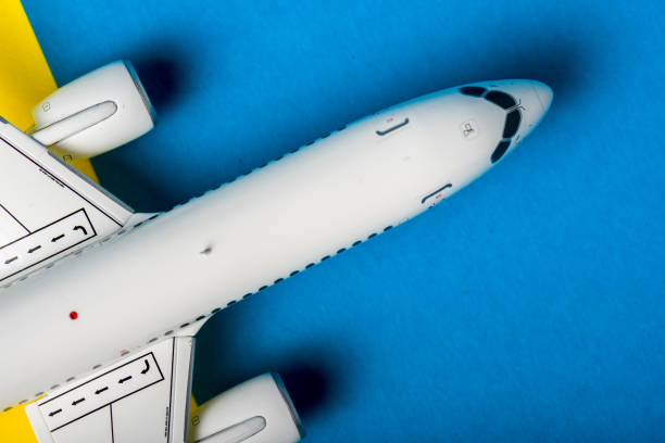 航空機モデルのトップビュー、青い机の上の飛行機。旅が始まります。旅行コンセプト - airplane seat ストックフォトと画像