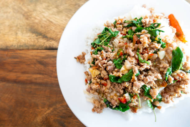 istock Rice topped with stir-fried pork and basil in a white dish. (Front focus) 1199528121