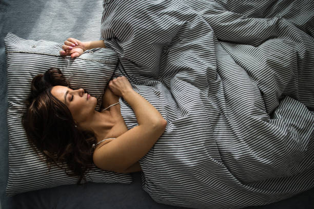 istock Pretty, young woman in her bed, fast asleep. 1199528799