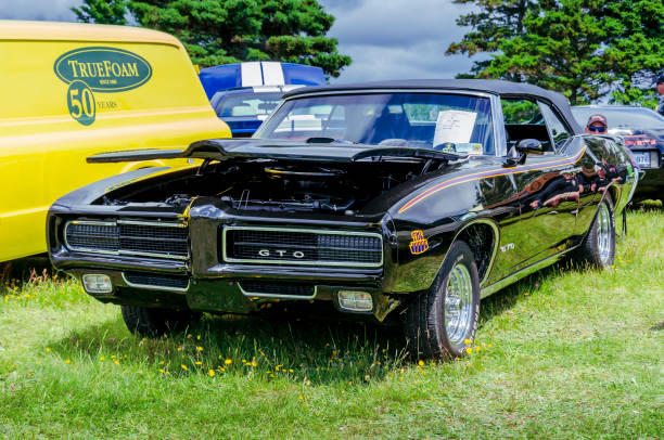 Stony Stratford,UK - June 2nd 2024: 1969 orange Pontiac GTO classic American car driving on a British country road