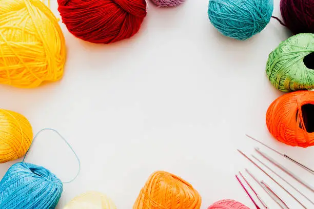 Knitting course. Creative hobby leisure. Multicolor threads crochet hooks on white background.