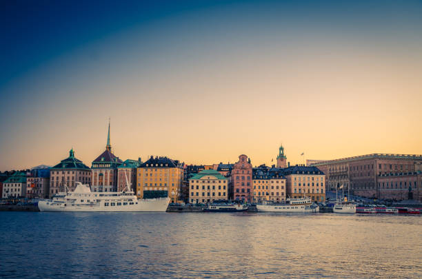 Old quarter Gamla Stan with traditional buildings, Stockholm, Sweden Old historical town quarter Gamla Stan with traditional typical buildings with colorful walls, Royal Palace on Stadsholmen island, white ship boat on Lake Malaren water at sunset, Stockholm, Sweden strommen stock pictures, royalty-free photos & images