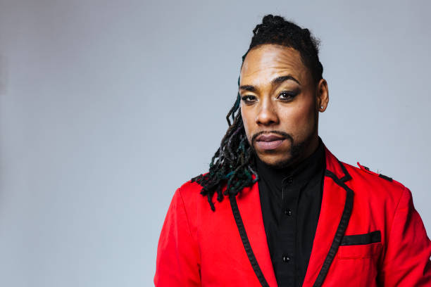 Studio portrait of a man wearing a red jacket suit and dreadlocks Studio portrait of a man wearing a red jacket suit and dreadlocks. White background. Single person. non binary gender photos stock pictures, royalty-free photos & images