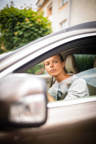 istock Pretty, young woman  driving a car 1199538029
