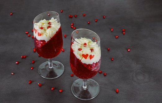 Dessert for Valentines Day or wedding, berry gelatin with vanilla mousse on dark background.