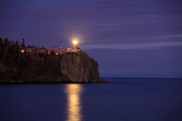 lighted lighthouse at dusk - split rock lighthouse state park stockfoto's en -beelden