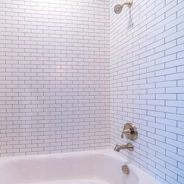 Square frame Clean white tiled shower combination tub cubicle in a modern bathroom interior