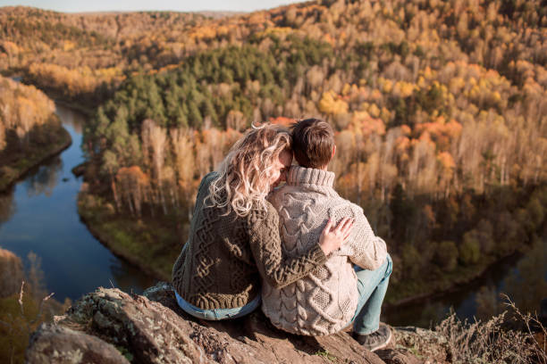 istock Young Romantic Couple Sitting On The Mountain Peak Top 1199555510