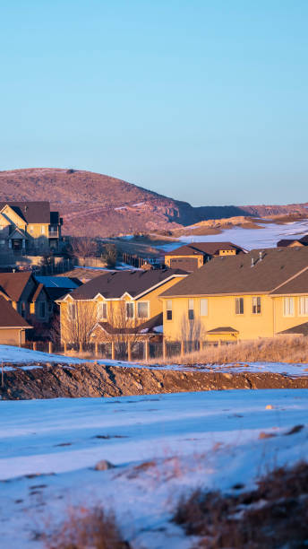 istock Vertical frame Snowy field bordering a modern housing estate 1199556198