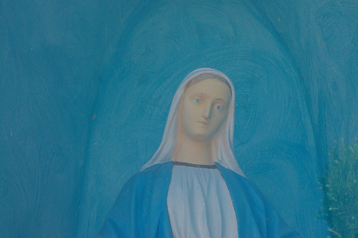 Varese, Lombardy, Italy - 1st September 2019 : Close up of a beautiful painting that portraits the Virgin Mary (Maria) on a blue background