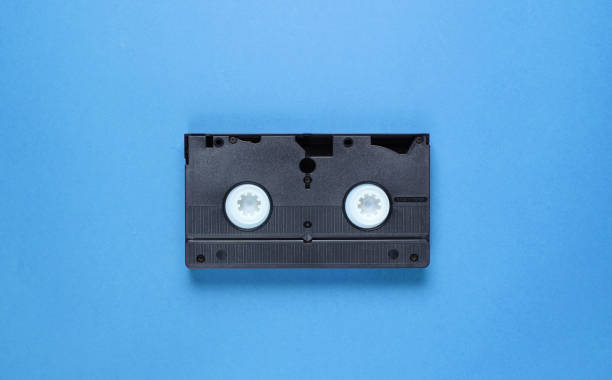 istock Pop culture retro attributes 80s, video cassette on blue background. Top view 1199568394