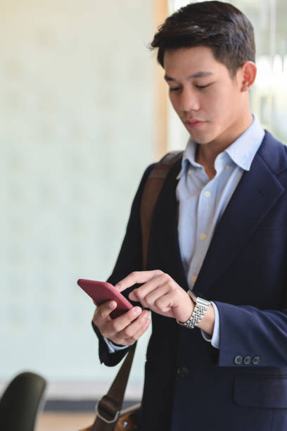 istock Close up view of businessman using on smartphone while standing in office room 1199568779
