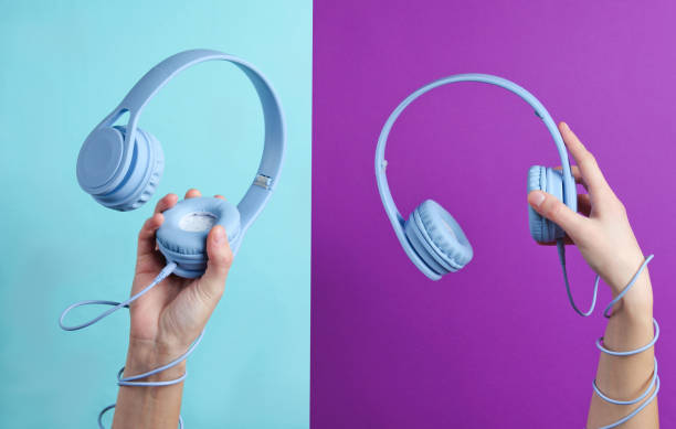 istock Two Hand wrapped cable holds headphones on blue purple background 1199570739