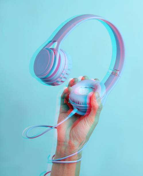 istock Hand wrapped cable holds headphones on blue background. Glitch effect 1199570762