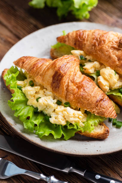 istock Croissant filled with scrambled eggs, cheese and green lettuce leaf salad 1199570838