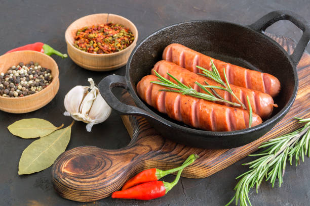 istock Fried sausages on a cast iron pan. 1199571168