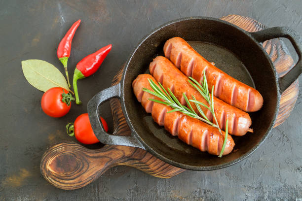 istock Fried sausages on a cast iron pan. 1199571183