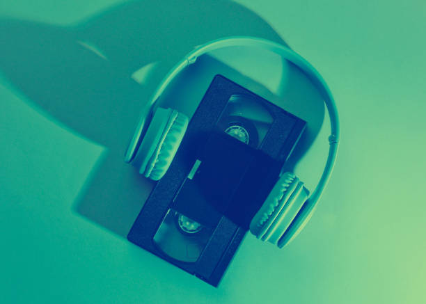 Video cassette with headphones. Retro wave, neon light, ultraviolet. Top view, minimalism