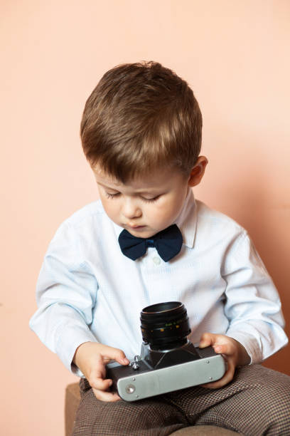 istock Little boy with aged retro camera. Child with an old camera 1199575274
