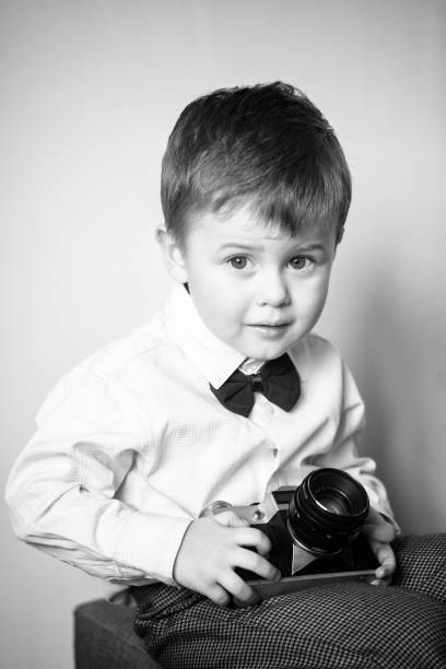 istock Little boy with aged retro camera. Child with an old camera 1199575275