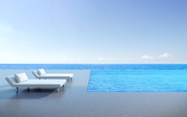 istock View of day bed on terrace and infinity pool, sea view background,Blue pool. 3D rendering 1199580820