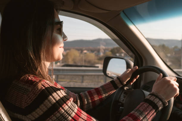 istock young woman drives a car. 1199583090