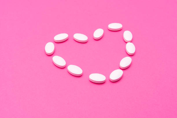 istock White oval pills lie on a pink background. Copy space, macro 1199584135