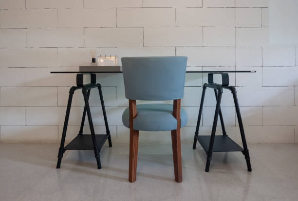 istock Front view of modern working table in front of white brick wall. Work place with empty loft table. 1199585024