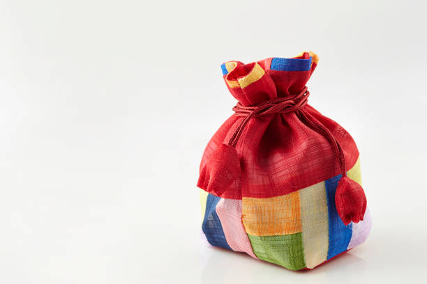 Small linen bag filled with dried lavender decorated with lacework and violet ribbon coque, two sachets, one is opened. Square. Composition on thenatural flaxen background.