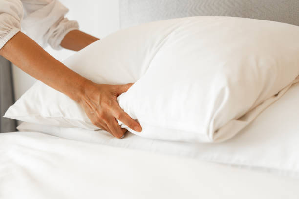 istock Female Hand set up white bed sheet in bedroom 1199596532