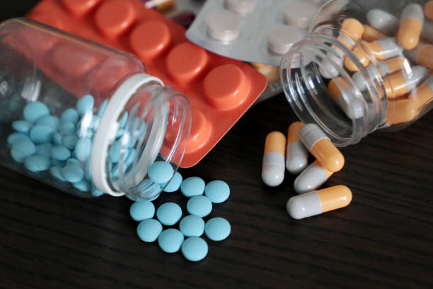 어두운 나무 테이블에 알 약과 캡슐, 여러 가지 빛깔의 약물 클로즈업의 많은 - capsule pharmacy addiction antibiotic 뉴스 사진 이미지