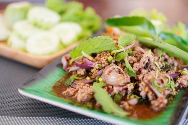istock Spicy minced meat salad with blurred cucumbers background, Thai menu 1199597769