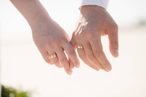 istock Man and woman hold hands close up 1199598451