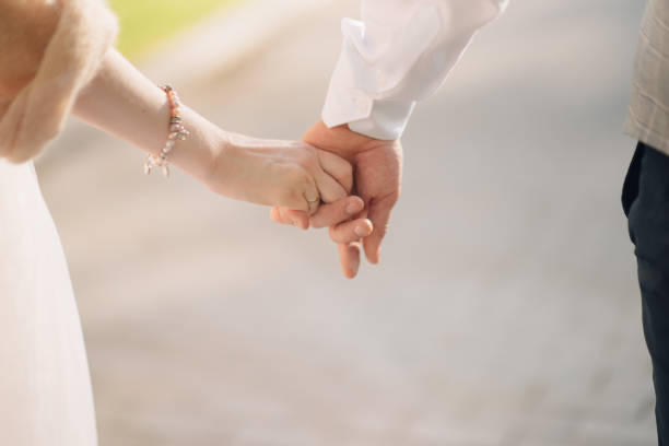 istock Man and woman hold hands close up 1199598481