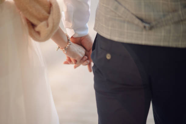 istock Man and woman hold hands close up 1199598500