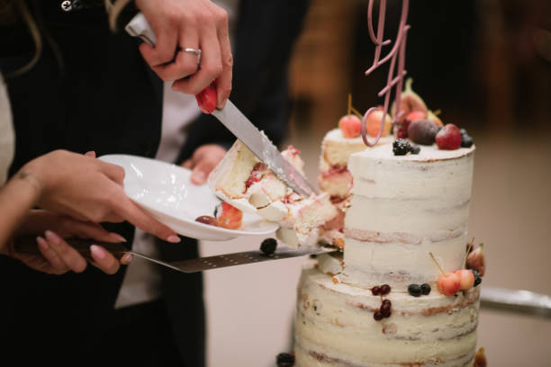 istock Bride and groom cut the wedding cake close up 1199604441