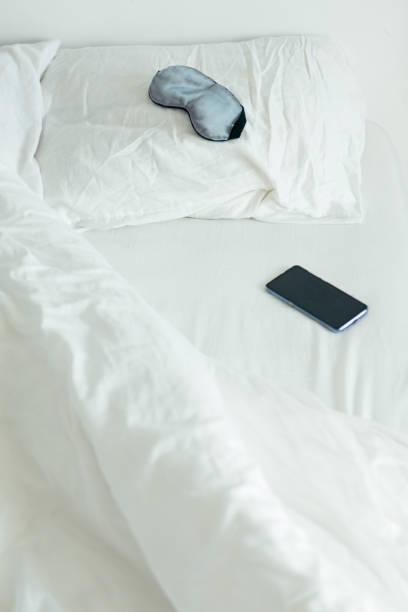 istock sleeping mask with phone at bed with white sheets sunny morning 1199604700