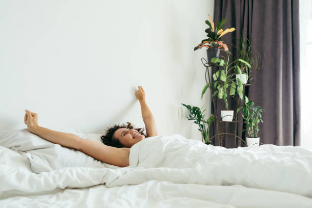 istock young pretty woman in bed with white sheets bright light 1199604709