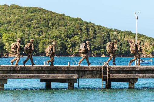 Les Trois-Ilets, Martinique - December 13, 2018: French soldiers run along the pier in Anse-a-l'Ane bay, Les Trois-Ilets, Martinique.
