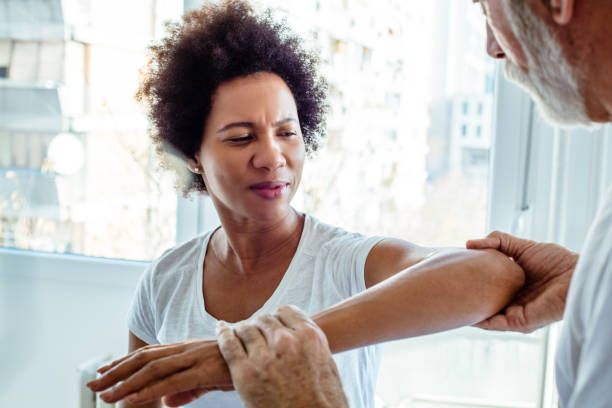 Problem is at the elbow. Problem is at the elbow. Physiotherapist working with patient. Managing Arthritis in Black Women stock pictures, royalty-free photos & images
