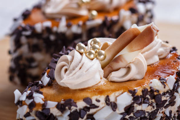 istock cakes with chocolate chips  and cream decorations  on wooden board on white background. selective focus, close up. 1199606243