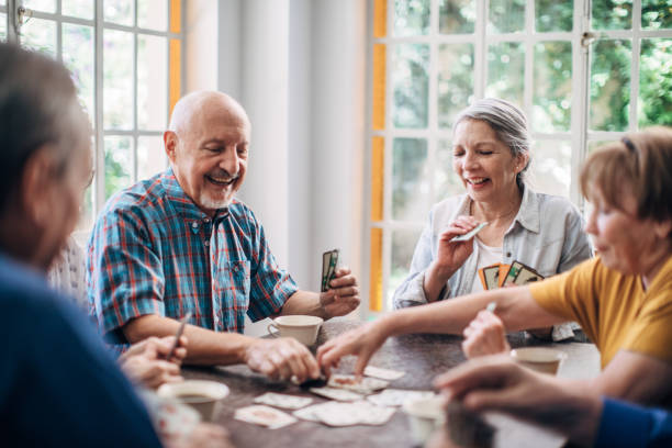 istock Senior friends having fun playing cards 1199607710